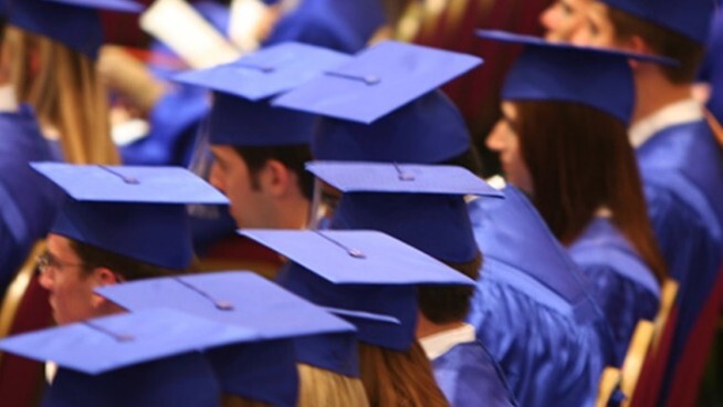Graduates in a row wearing their caps and gowns. 